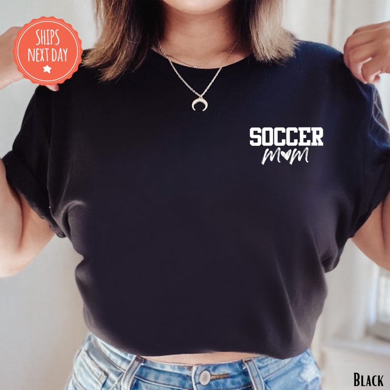 A person wearing a black t-shirt with the text "SOCCER MOM" printed on it.