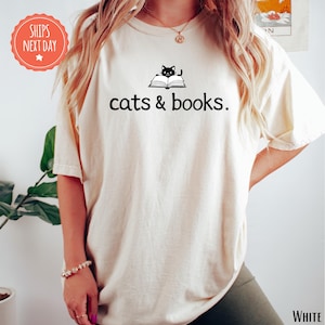 a woman wearing a t - shirt that says cats and books