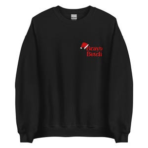 May include: Black crew neck sweatshirt featuring a red Santa hat and the text "Bravo Betch" in red. The design is on the upper left chest. The sweatshirt is made of a soft material, perfect for cooler weather.