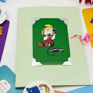 Green Peppermint patty playing card attache dot green pearlescent card. Patty is on the phone.