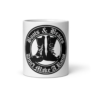 May include: White ceramic mug with a black and white graphic of boots and the text "Boots & Braces Don't Make A Racist".