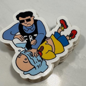 May include: A stack of stickers featuring a cartoon illustration of a man in a blue shirt and black sunglasses pouring water on a person lying on the ground. The man is wearing a badge that says "FBI".