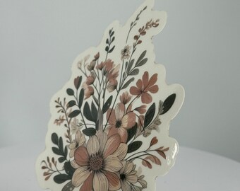 May include: A sticker featuring a floral design with brown and white flowers and leaves on a white background.