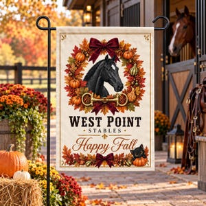 Puede incluir: Una bandera de jardín rectangular con una cabeza de caballo negra centrada en una corona otoñal de hojas naranjas, calabazas y un lazo rojo oscuro. Debajo, el texto dice WEST POINT STABLES y Happy Fall, con un pequeño gato negro sentado.