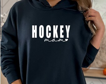 Könnte beinhalten: Schwarzer Hoodie mit einem weißen Aufdruck, der "HOCKEY mom" mit einem kleinen weißen Herz sagt.