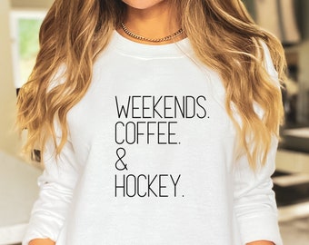 Könnte beinhalten: Weißer Pullover mit schwarzem Text, der "Weekends. Coffee. & Hockey." lautet.