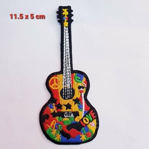 May include: A colourful embroidered patch of a guitar with peace signs, stars, and the word "LOVE" on it. The patch is 11.5 cm by 5 cm.