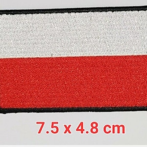 May include: A white and red embroidered patch of the Polish flag with black stitching around the edges. The patch measures 7.5 x 4.8 cm.