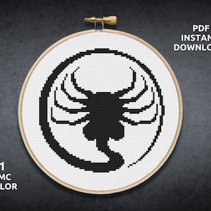 May include: A black and white cross-stitch pattern of the Alien Xenomorph from the movie Alien. The pattern is in a circular hoop and is ready to be stitched.
