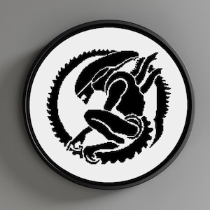 Può includere: Silhouette in bianco e nero di una creatura aliena con un design circolare a forma di ingranaggio attorno ad essa. L'alieno è accovacciato e ha una lunga coda.