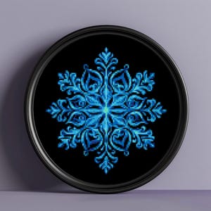 May include: A blue snowflake design on a black background in a round black frame.