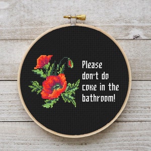 May include: Black embroidery hoop with a white background and red poppy flowers. The text reads "Please don't do coke in the bathroom!"