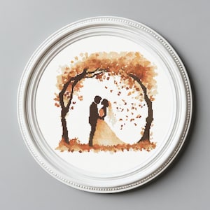 Puede incluir: Un patrón de punto de cruz con una pareja de pie bajo un árbol marrón y naranja con hojas que caen. La pareja está en silueta negra.