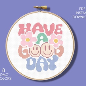 Könnte beinhalten: Kreuzstichmuster mit dem Spruch "Have a Good Day" im Retro-Stil mit Smiley-Gesichtern und Blumen. Das Muster ist für die Verwendung mit 8 DMC-Farben konzipiert.