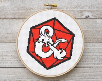 May include: A red and white cross-stitch embroidery of a Dungeons and Dragons dice with a dragon symbol.