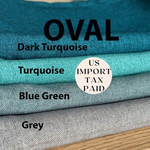 Puede incluir: Una pila de cuatro muestras de tela en tonos turquesa oscuro, turquesa, azul verdoso y gris. La palabra "OVAL" está impresa en letras negras grandes. Las palabras "Dark Turquoise", "Turquoise", "Blue Green" y "Grey" están impresas debajo. Una pegatina dice "US IMPORT TAX PAID".