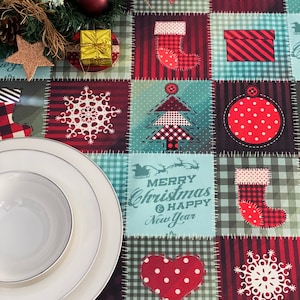 Peut inclure: Une nappe de Noël rouge et verte avec un motif patchwork. La nappe présente divers motifs de fêtes, notamment des flocons de neige, des sapins de Noël, des chaussettes, des cœurs et des ornements. Le texte "Joyeux Noël et Bonne Année" est imprimé au centre de la nappe.
