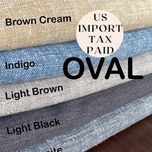 Könnte beinhalten: Nahaufnahme von Stoffmustern in verschiedenen Farben, darunter Braun-Creme, Indigo, Hellbraun, Hellschwarz und Anthrazit. Das Wort "Oval" ist deutlich zu sehen, zusammen mit dem Text "US Import Tax Paid" in einem Kreis.