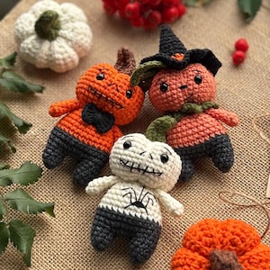 May include: A selection of handmade crochet Halloween decorations. The image shows several orange pumpkin figures with black detailing, a white skeleton figure, and a white pumpkin. The pumpkins have black bow ties and witch hats. The decorations are on a burlap surface.