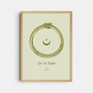 May include: A framed print with a gold Ouroboros design, a snake consuming itself, around a crescent moon symbol. The Greek text "Εν το Παν" and a triangle are below. The background is a pale green colour.