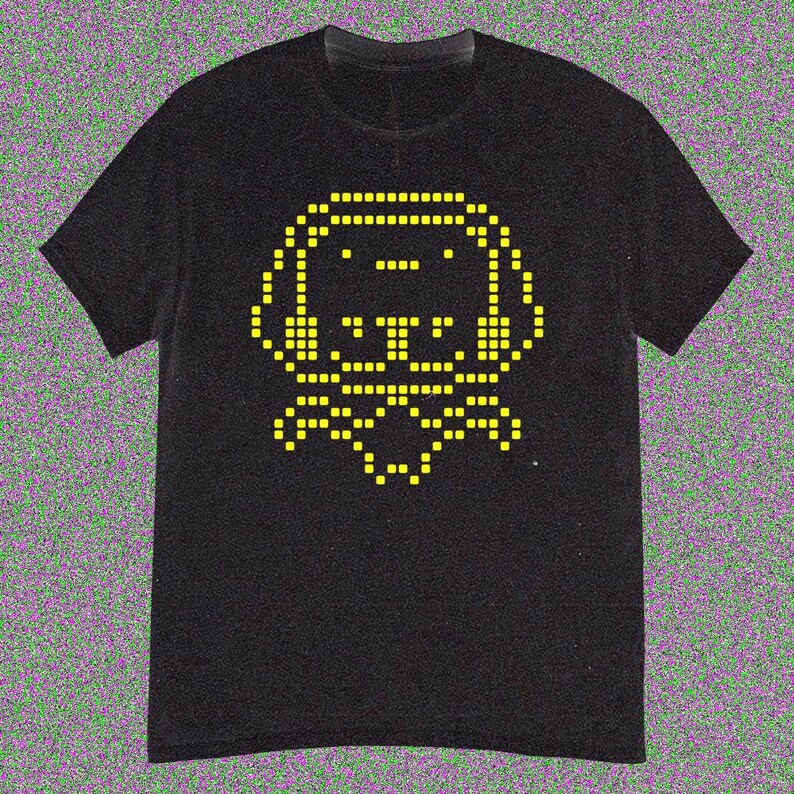 May include: Black t-shirt with a yellow pixelated dog graphic. The dog has large ears and a bow tie. The design is in the centre of the shirt. The t-shirt has short sleeves and a crew neck.