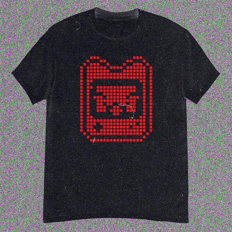 May include: Black t-shirt with a red pixelated graphic of a retro handheld gaming device. The design is centrally placed on the front. The t-shirt has short sleeves and a crew neck.