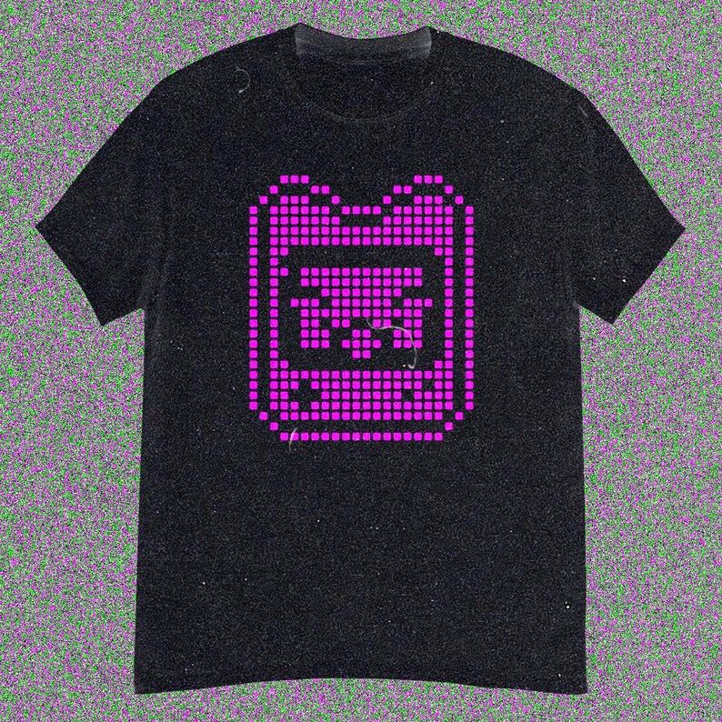 May include: Black t-shirt with a magenta pixelated graphic of a retro handheld gaming device. The design, made of small squares, is centrally placed. The shirt has short sleeves and a crew neck.