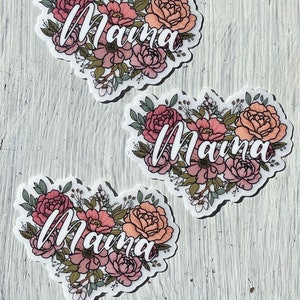May include: Three floral heart stickers with the word "Mama" written in white cursive lettering. The flowers are pink, peach, and white.