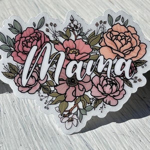 May include: A white sticker with the word "Mama" in cursive script surrounded by pink and peach flowers with green leaves.
