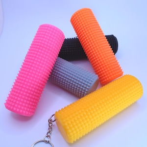 May include: Five colorful textured rollers attached to a silver key chain. The rollers are pink, orange, gray, black, and yellow.