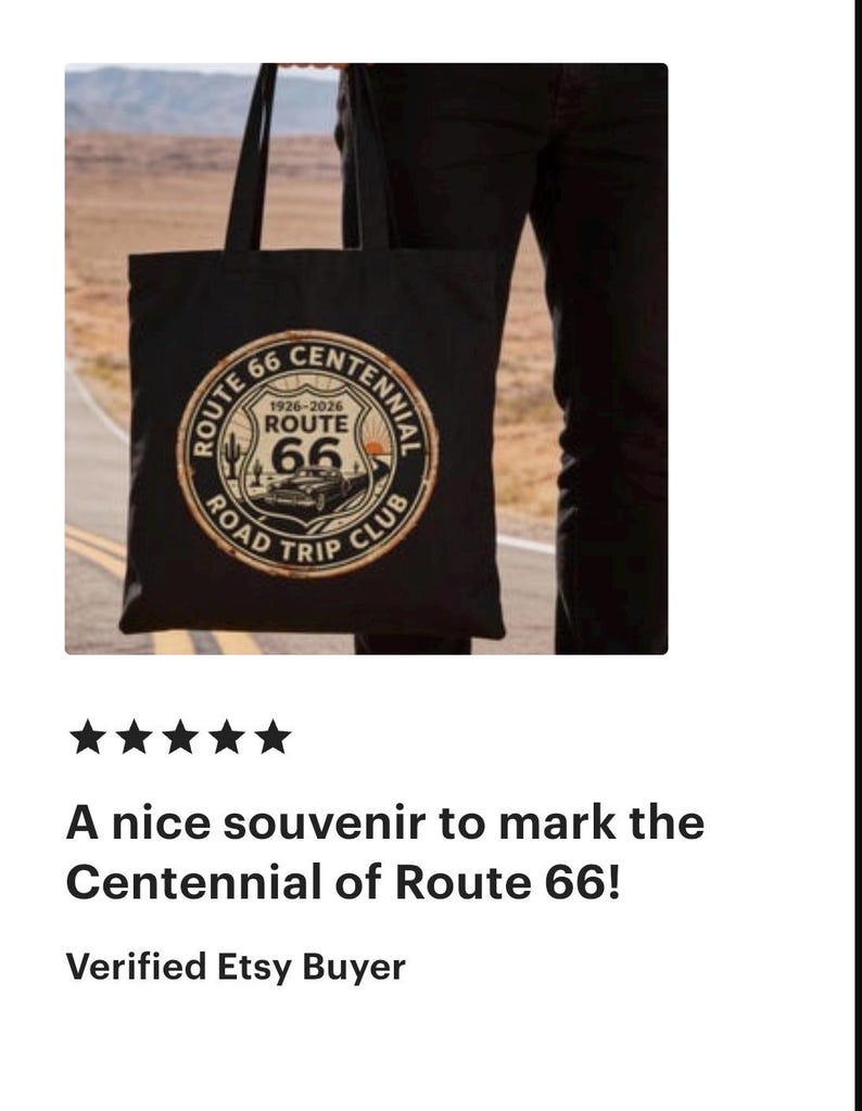 May include: Black tote bag featuring a Route 66 Centennial design. The circular emblem includes the text "Route 66 Road Trip Club" and the years "1926-2026". The design is in shades of brown, white, and black. The bag is held by a person.