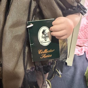 以下が含まれることがあります： 黒い持ち手と「But First, Coffee」の文字が黒い手書き風フォントで書かれた白いセラミックマグ。マグカップは白い表面に置かれています。
