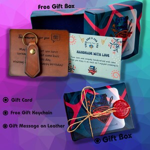 May include: A gift set with a brown leather keychain and a gift card. The set includes a gift box wrapped in blue and red patterned paper, tied with twine and sealed with red wax. The gift box also contains a card that says "Handmade with Love".