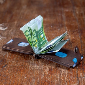 Open look of te Crazy dark brown leather wallet on the table. Featuring card slots and money clip.