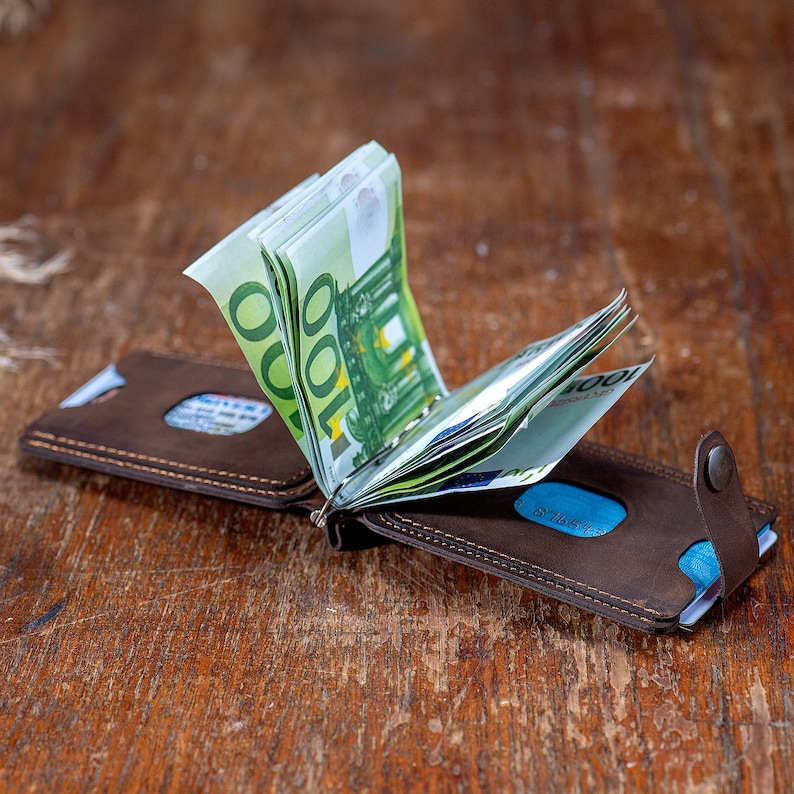 Open look of te Crazy dark brown leather wallet on the table. Featuring card slots and money clip.