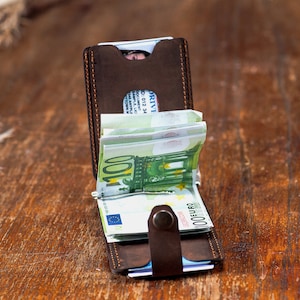 Open look of the Crazy dark brown leather wallet on the table. Featuring card slots and money clip.