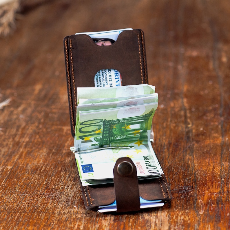 Open look of the Crazy dark brown leather wallet on the table. Featuring card slots and money clip.