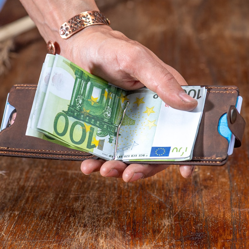 Open look of the Crazy dark brown leather wallet in hand. Featuring card slots and money clip.