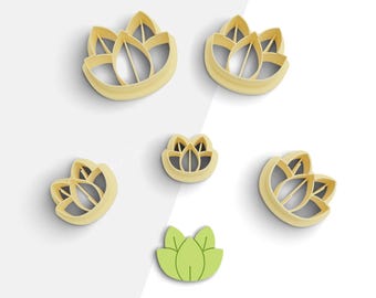 May include: Set of six cookie cutters in the shape of a lotus flower. The cutters are made of yellow plastic and come in different sizes. The smallest cutter is green.