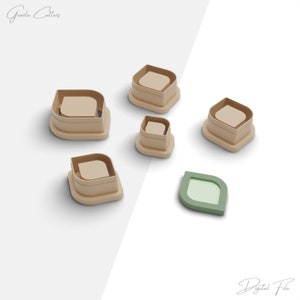 Puede incluir: Un conjunto de cortadores de galletas con forma de hoja beige y verde. Los cortadores son de varios tamaños y tienen una base cuadrada con una parte superior curvada. La imagen también incluye el texto "Grazia Cutters" y "Digital File".