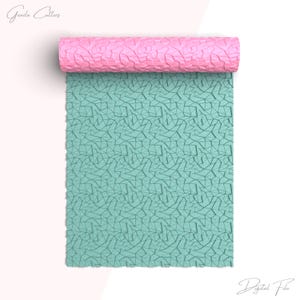 May include: A teal blue digital file with a geometric pattern. The file is rolled up and the pink underside is visible.