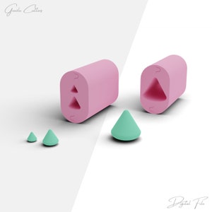 以下が含まれることがあります： 三角形のフォンダンまたはガムペーストの装飾を作るためのピンクのシリコンモールド2つ。モールドは、さまざまなサイズの緑色のフォンダンまたはガムペーストの三角形3つの隣に示されています。