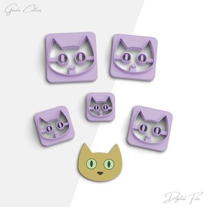 Puede incluir: Cinco cortadores de galletas de plástico morado en forma de gato de diferentes tamaños. El cortador más grande es un cuadrado con una cara de gato, el siguiente en tamaño es un cuadrado con una cara de gato, el siguiente en tamaño es un cuadrado con una cara de gato, el siguiente en tamaño es un cuadrado con una cara de gato, y el cortador más pequeño es una cara de gato con un cuerpo amarillo.