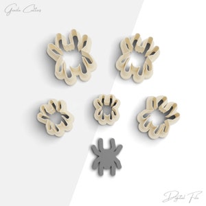 May include: Set of six cookie cutters in the shape of spiders. The cutters are beige and come in various sizes. There is also a single gray spider cookie cutter.
