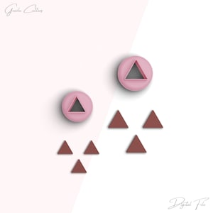 May include: Set of pink and brown triangle cookie cutters. The pink cutters are round with a triangle cut out. The brown cutters are simple triangles.