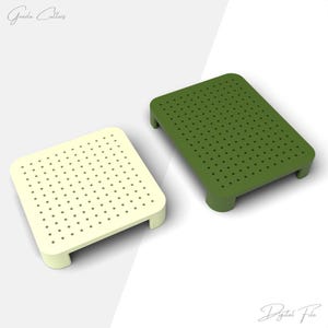 Può includere: Due piattaforme rettangolari perforate. Una è giallo pallido, l'altra verde oliva. Ogni piattaforma ha angoli arrotondati e gambe corte. Le piattaforme sono progettate con fori distanziati uniformemente sulla loro superficie.