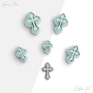 May include: Set of six cookie cutters in the shape of a cross. The cutters are light blue and have a slightly textured finish. The cutters are arranged in a scattered pattern on a white background. The text "Digital File" is visible in the bottom right corner of the image.