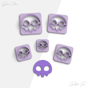 May include: Set of six purple plastic skull cookie cutters. The cutters are in various sizes and shapes, including a traditional skull with eye sockets and a skull with a rounded top.