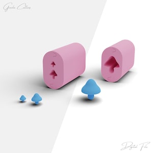 Puede incluir: Dos moldes de silicona rosa con un diseño de hongo. Los moldes se muestran junto a tres objetos con forma de hongo azul.