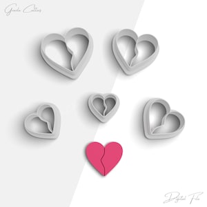 Könnte beinhalten: Fünf weiße Plastik-Ausstecher in Form von gebrochenen Herzen und ein rosa gebrochenes Herz-Keks.